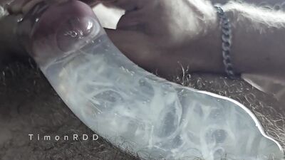 The guy cums in a condom with hot water with powerful volleys