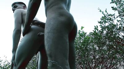Muscle man plays with a young stud in a woods